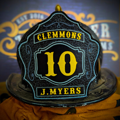 Black leather firefighter helmet shield with yellow number 10, Clemmons lettering, and J. Myers name in bold.