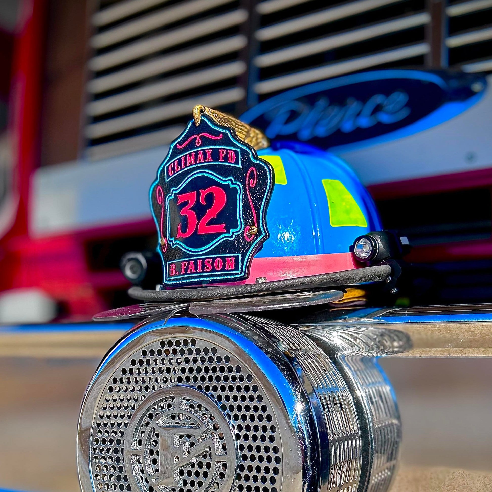 Blue firefighter helmet with black leather shield featuring red number 32, Climax FD text, and name B. Faison at the bottom.