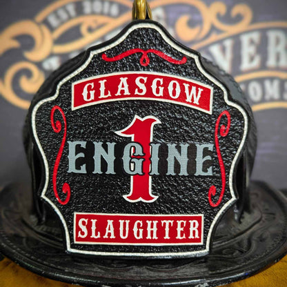 Black leather firefighter helmet shield with bold red number 1 and engine lettering, custom fire department gear.