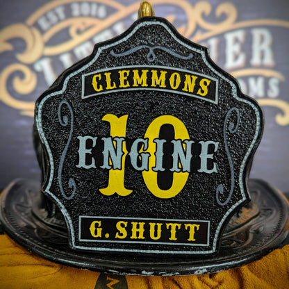 Black leather firefighter helmet shield with bold yellow number 10 and engine lettering, custom fire department gear.
