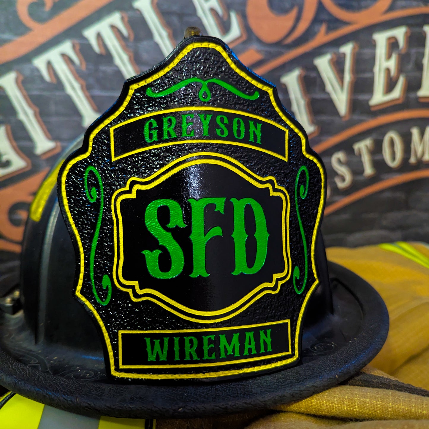 Black leather firefighter helmet shield with green SFD lettering, yellow outline, and name Greyson Wireman.