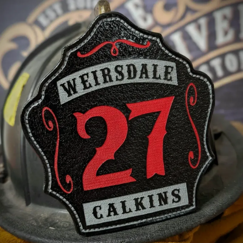 Standard Issue custom firefighter helmet shield in black leather with bold red 27, gray Weirsdale lettering, and Calkins nameplate accent.
