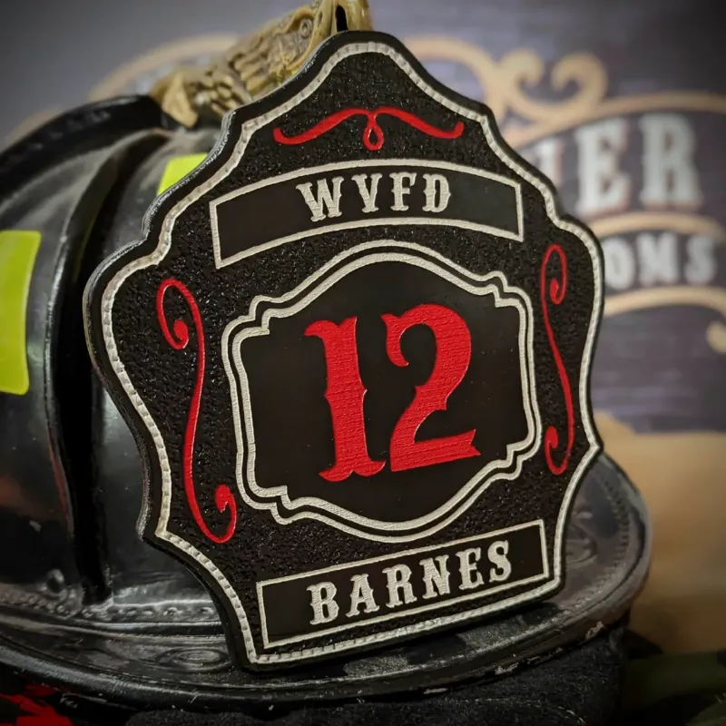 Standard Issue custom firefighter helmet shield in black leather with bold red 12, WVFD lettering across the top, and Barnes nameplate at the bottom.