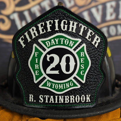 Custom leather firefighter helmet shield with Maltese cross design and fire department details.