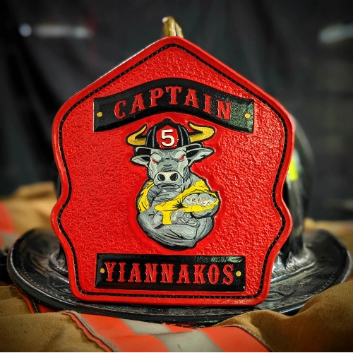 Custom leather firefighter helmet shield with engraved company number.