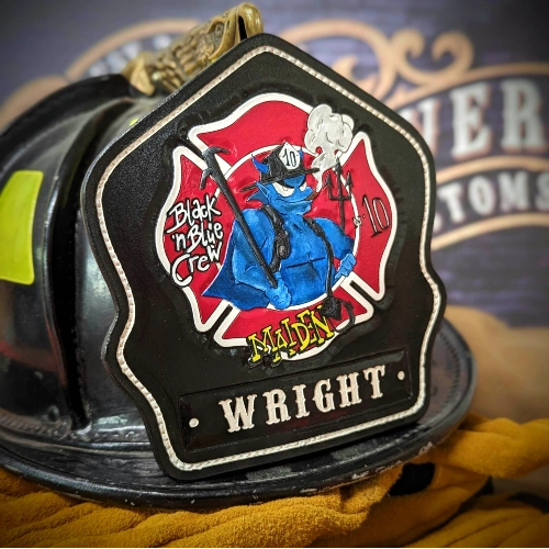 Handcrafted firefighter helmet shield with raised numbers and detailed stitching.
