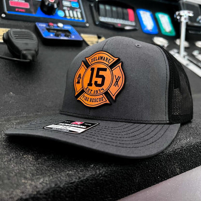 Charcoal Richardson firefighter hat with custom Maltese leather patch design, professional gear for fire rescue crews.