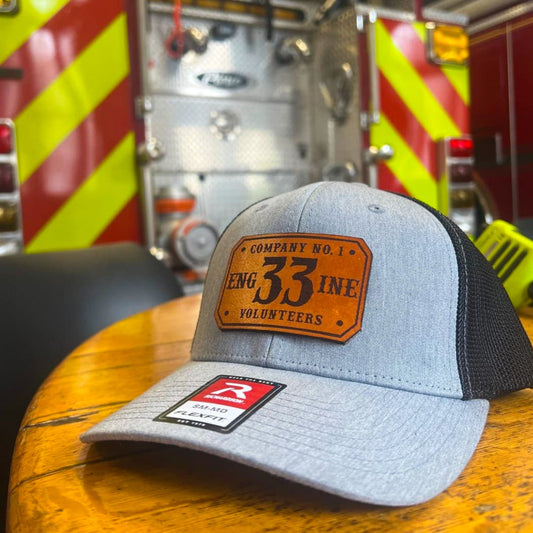 Gray and black Richardson firefighter hat with a custom leather patch design, built tough for firehouse pride.