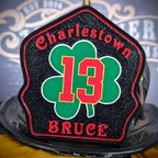 Firefighter helmet shield with green shamrock emblem