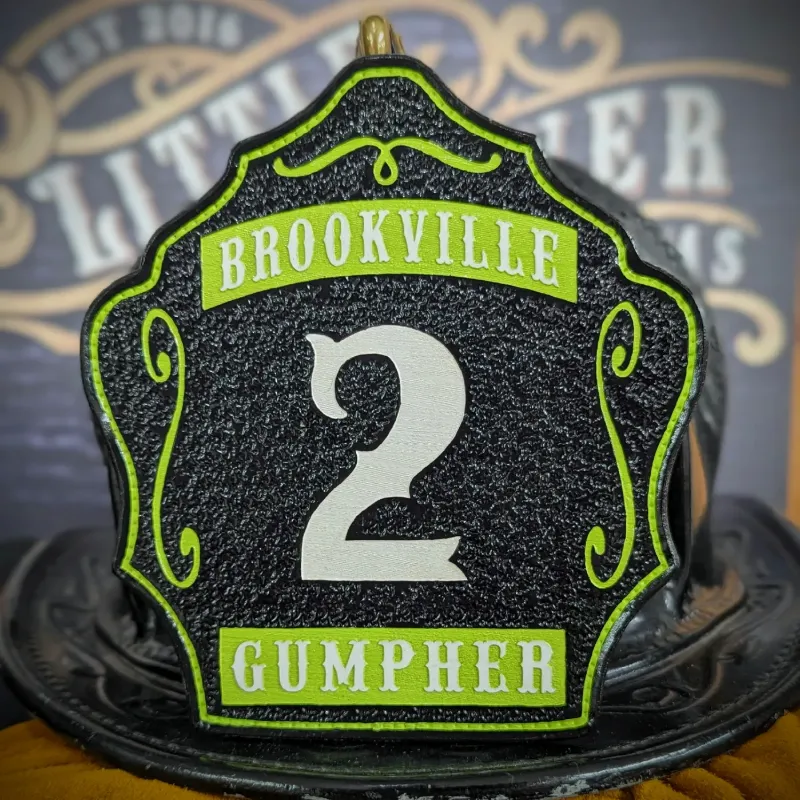 Standard Issue custom leather firefighter helmet shield in black with white number, bright green panels, and decorative trim.