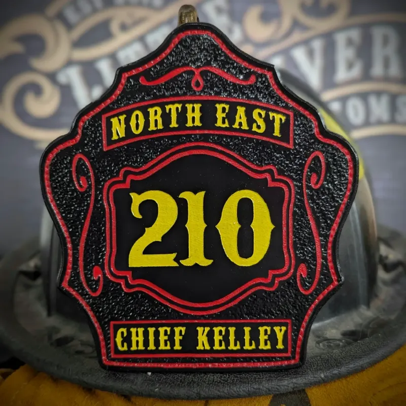 Standard Issue custom leather firefighter helmet shield for Chief in black with yellow numbers, red trim, and gold department text.