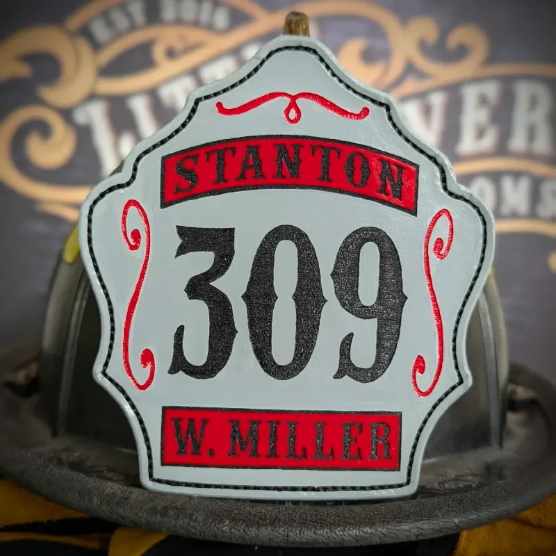 Standard Issue custom leather firefighter helmet shield in gray with bold black numbers, red panels, and decorative trim accents.
