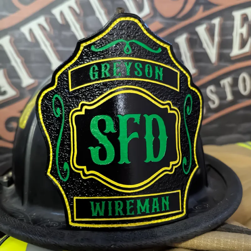 Standard Issue custom leather firefighter helmet shield for Wireman in black with green lettering, gold outline, and decorative trim.