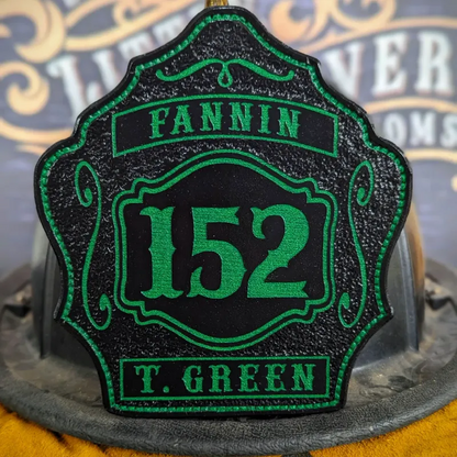 Standard Issue custom leather firefighter helmet shield in black with green numbers, department lettering, and decorative trim.