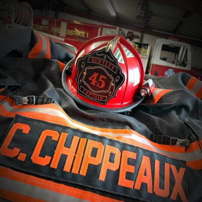 Red firefighter helmet with black leather shield, gold accents, number 45, and Captain Bentley text displayed on fire gear.