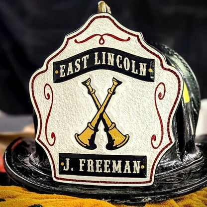 black firefighter helmet shield with gold crossed bugles—classic layout.